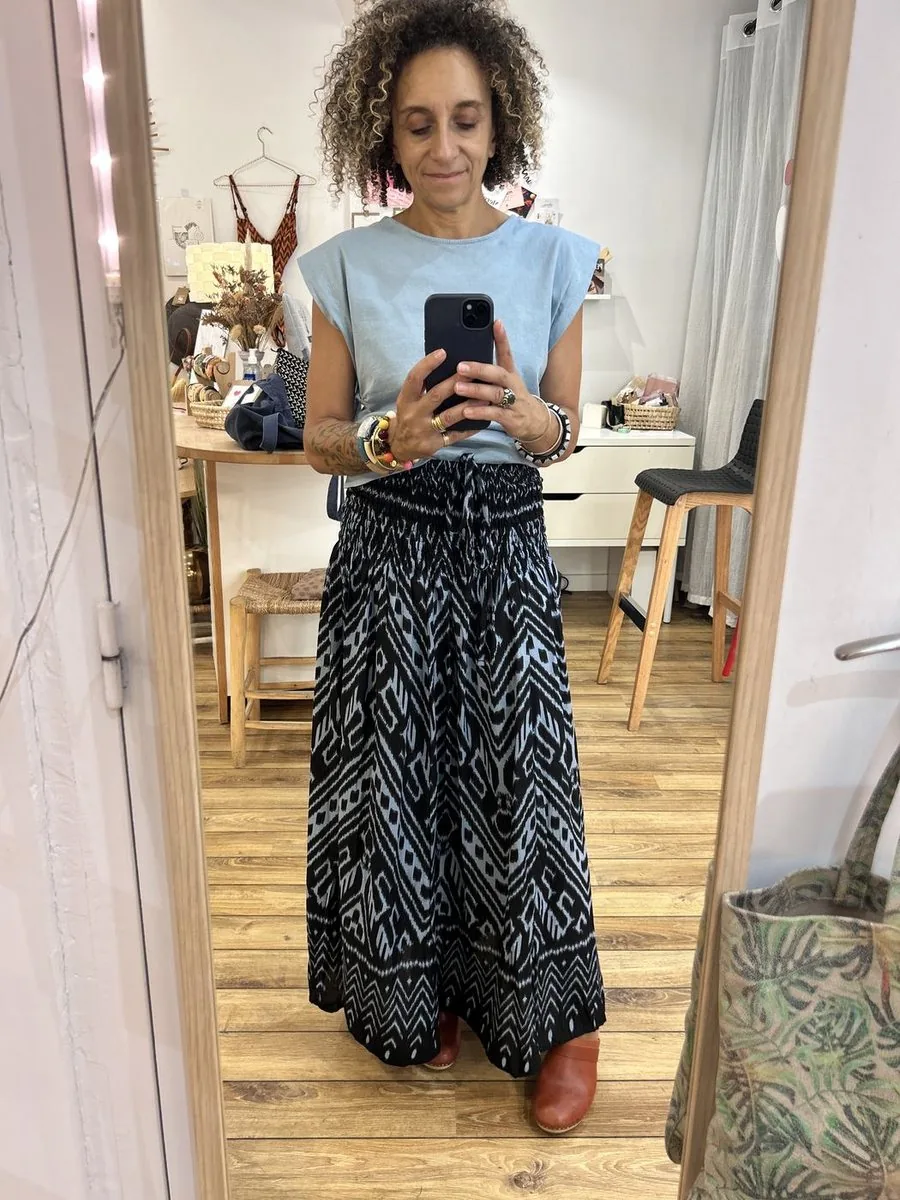 Dans la cabine : essayage d’un pantalon large imprimé, vu dans le miroir en pied.