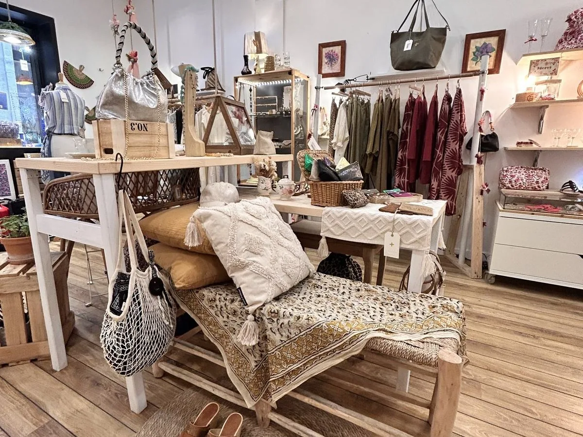 Fauteuil de rotin et petite table basse, près d’un portant de vêtements.