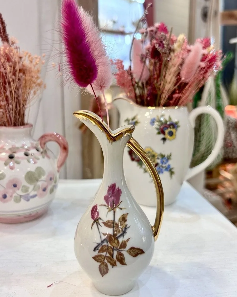 Petit pichet chiné à filet doré, posé devant un bouquet de fleurs séchées.