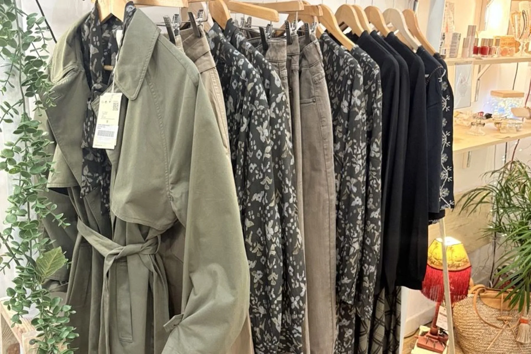Portant de vêtements en lin et coton, une chemise à nœud en vichy au premier plan.