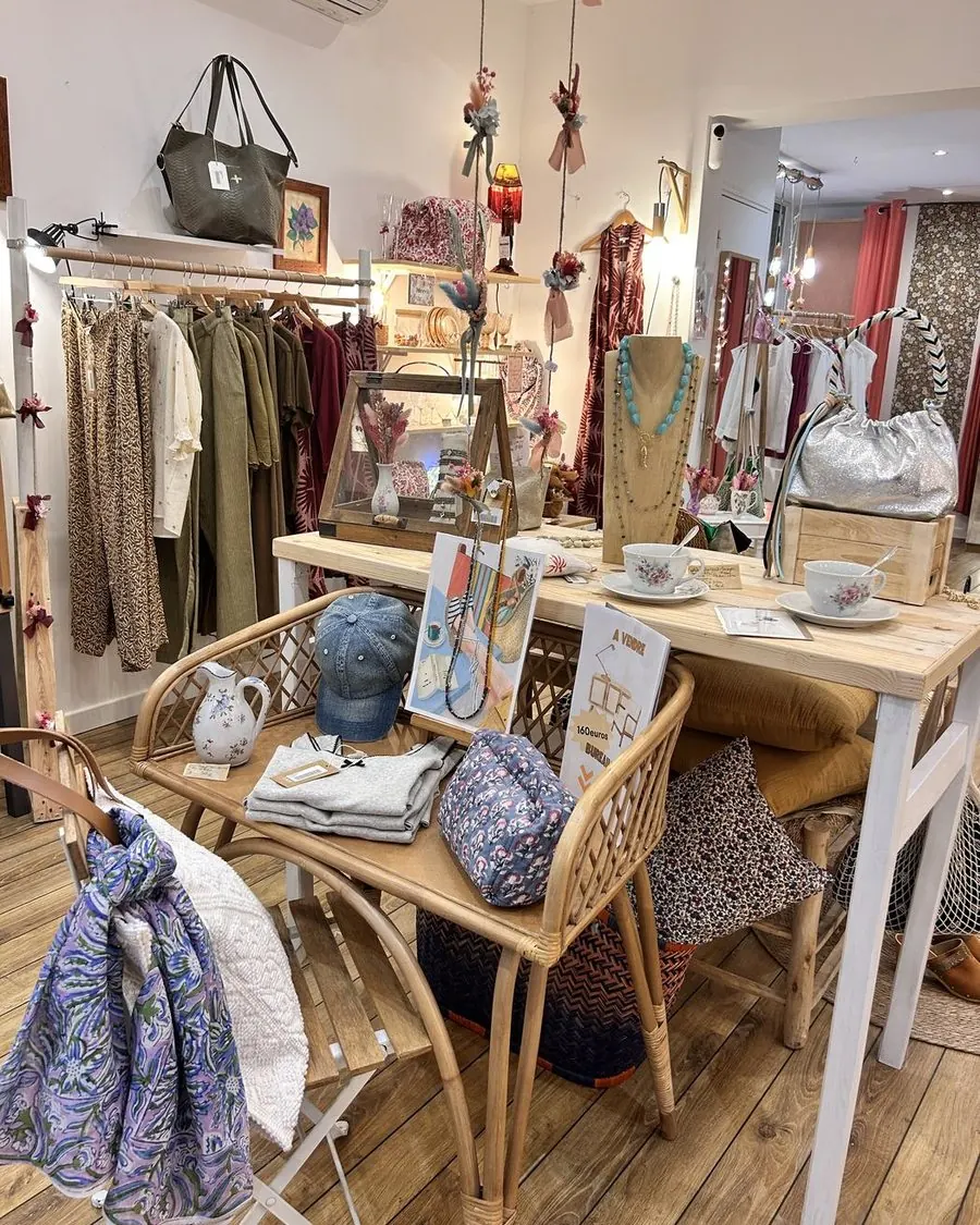 La table centrale entourée de chaises de rotin, foulards et cartes posés dessus.