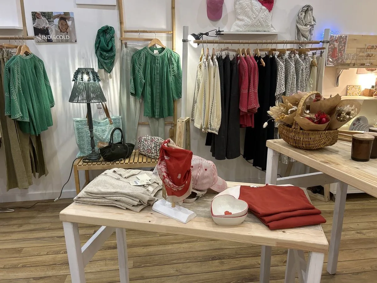 Table centrale couverte de lainages pliés, d’un plateau et de textiles rouges.