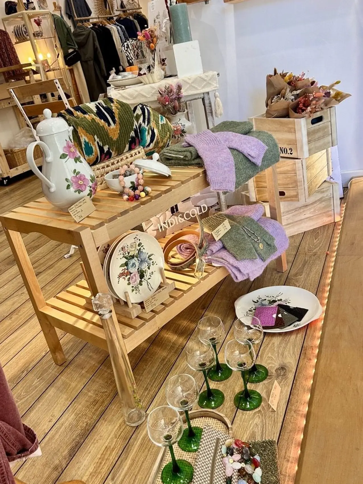 Vitrine de septembre : théière en faïence, sacs en raphia et plantes en pot.